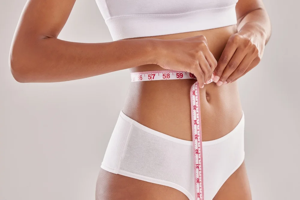 Woman measuring her waist